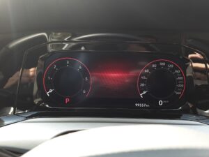 Digitales Auto-Display mit Tachometer. Der Hintergrund ist schwarz mit roten Akzenten.