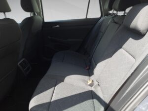 Rückbank eines Autos mit grauen Sitzen, Sonnenlicht fällt durch das Fenster.