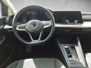 Innenraum eines modernen Autos, schwarzes Interieur, minimalistische Instrumententafel.