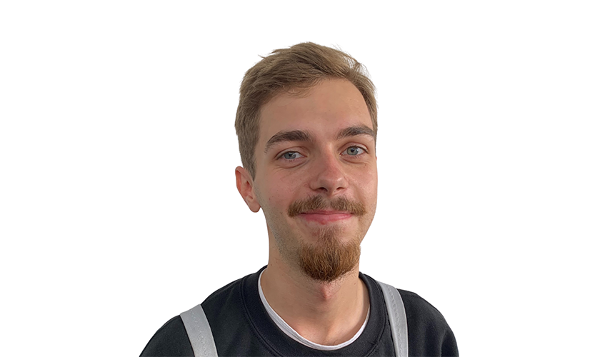 Ein lächelnder Mann mit braunen Haaren und einem Spitzbart trägt ein schwarzes Hemd