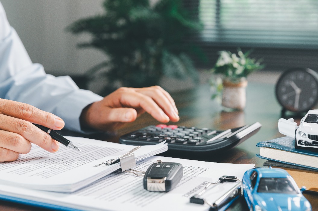 Geschäftsfrau beim Unterschreiben einer Kfz-Versicherung oder eines Leasingvertrags.