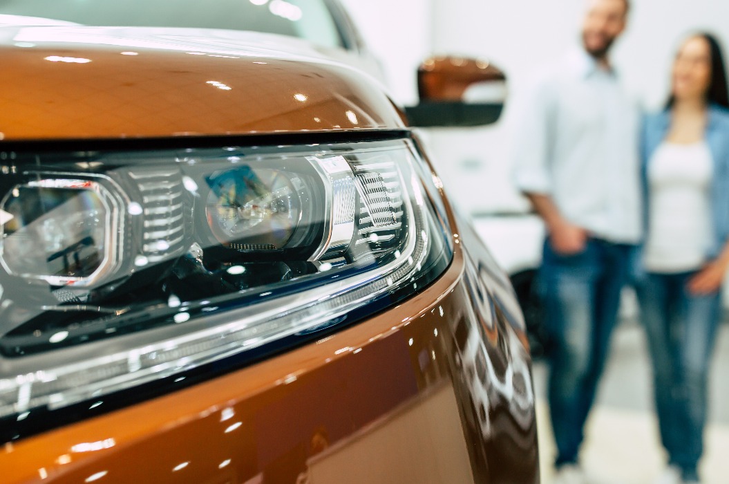 Junges Paar kauft ein neues Auto im Autohaus
