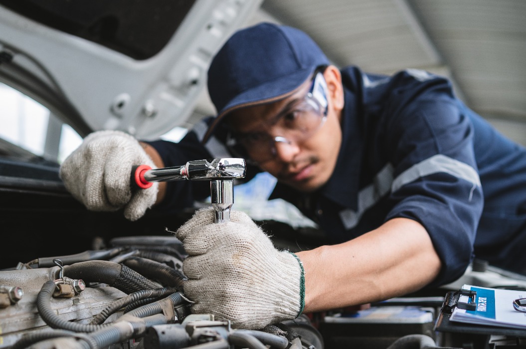 Ein Techniker in Uniform arbeitet an einem Fahrzeug, das einer Inspektion unterzogen wird